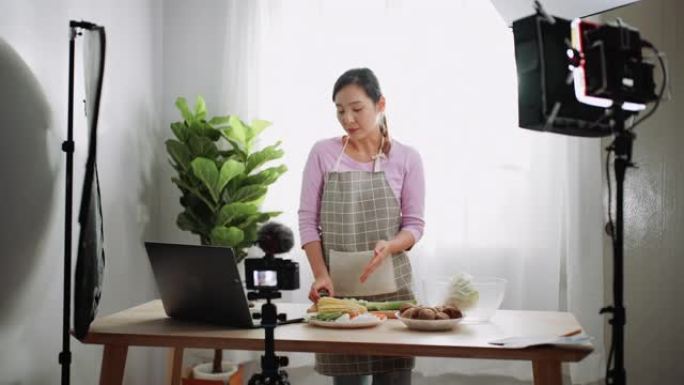 亚洲妇女为追随者准备饭菜和直播视频，影响者促进健康营养
