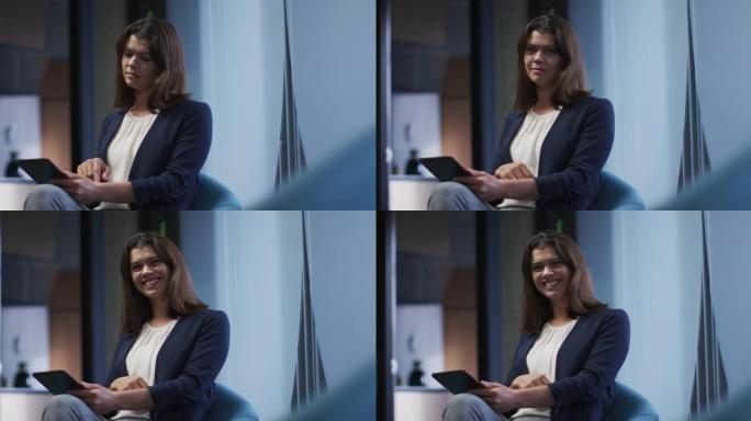 现代办公室中使用平板电脑的棕色头发微笑女商人肖像