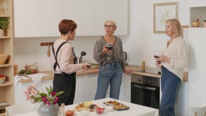 三名成年妇女在厨房喝酒聊天