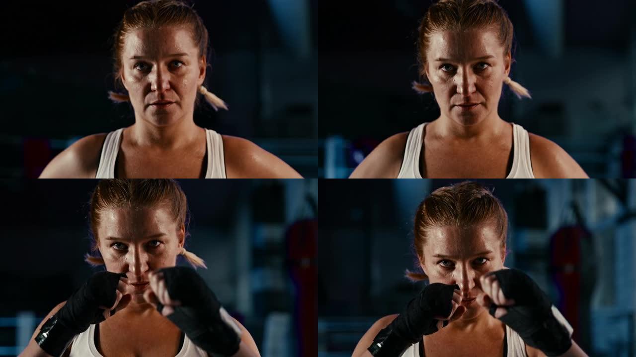 慢动作出汗的女拳击手在镜头前摆出战斗姿势