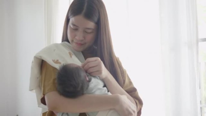 亚洲妈妈抱着她可爱的宝宝。