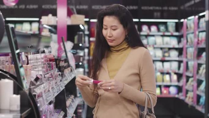 亚洲女性在化妆品商店购物
