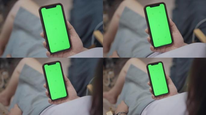 女人在家中使用色度键绿屏智能手机，多莉拍摄