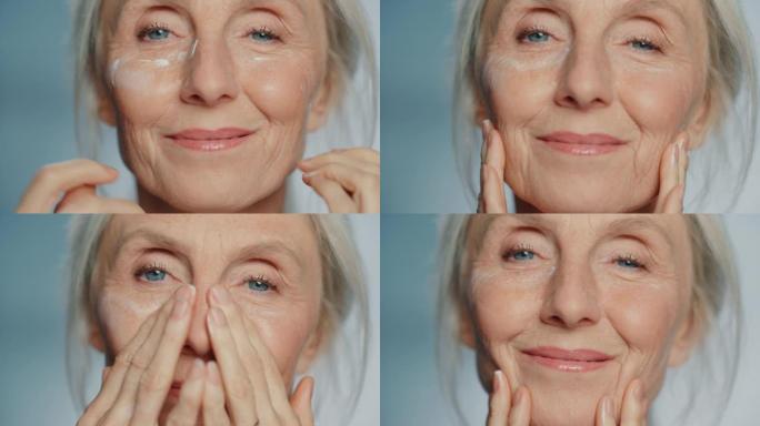 美丽的高级女人的肖像在眼霜下轻轻涂抹。老年女士用天然抗衰老化妆品使皮肤柔软、光滑、无皱纹。美容护肤、