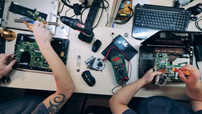 工程师正在俯视图中修复笔记本电脑中的微电路