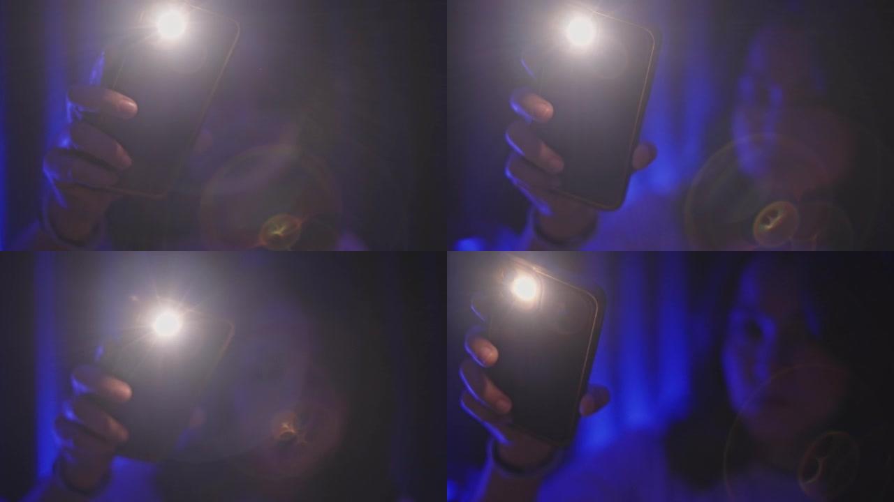 女人在智能手机上使用手电筒，特写镜头