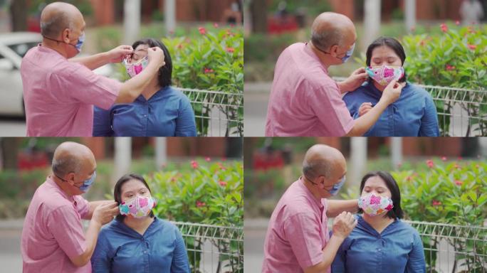 亚洲马来人退休父亲在城市街道帮助他的唐氏综合症女儿戴口罩
