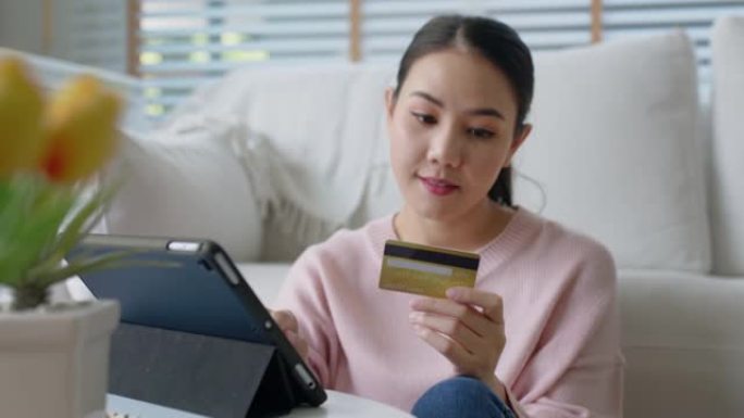 亚洲女性支付信用卡购物网上商店在家快乐。