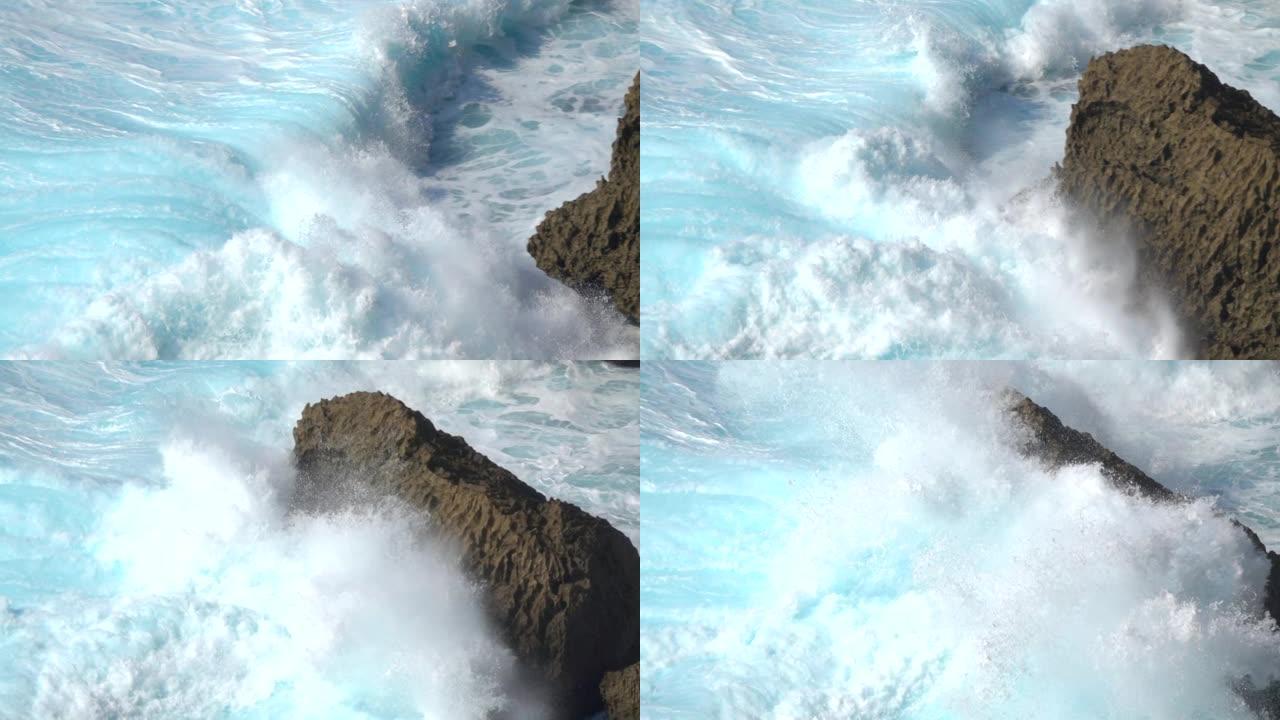 慢动作: 碧绿的海浪冲破了巴厘岛的黑色火山岩。