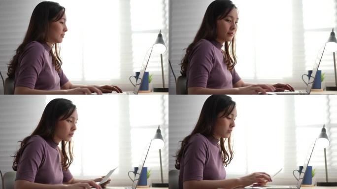 亚洲妇女在家中使用笔记本电脑工作