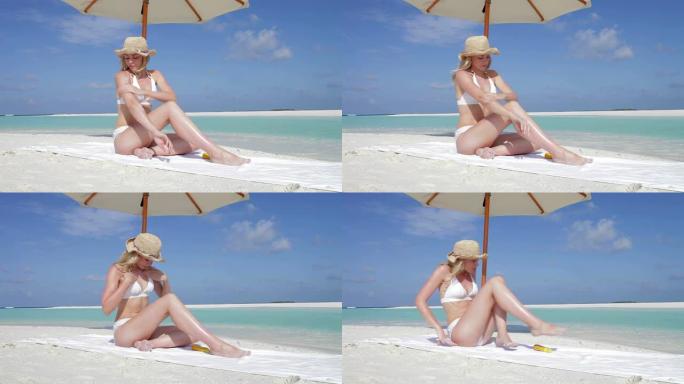 女人在海滩度假时涂防晒霜