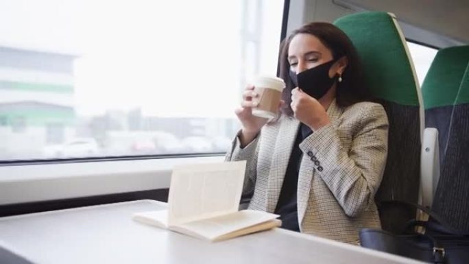在健康大流行期间，火车上的女商人试图通过PPE口罩喝外卖咖啡