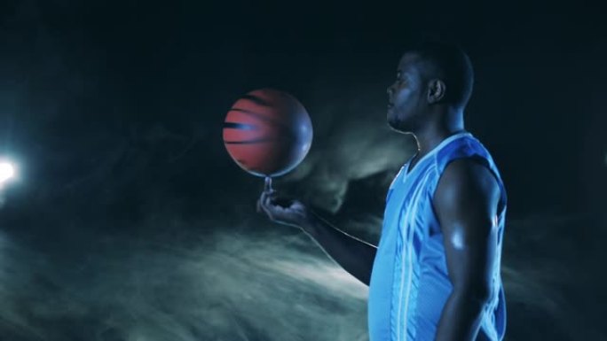 非裔美国运动员正在用手指旋转篮球