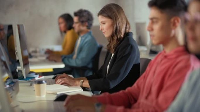 美丽聪明的女学生，在现代大学学习，有不同的多民族同学。微笑的大学学者在大学教室工作，学习IT，软件工