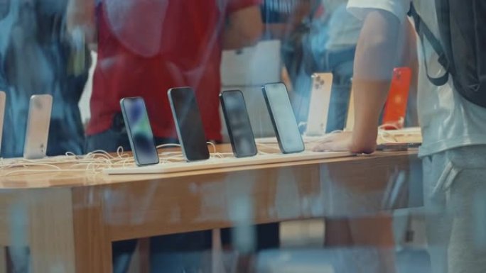 选择在电子商店的商店橱窗附近购买新智能手机的人们的特写镜头。