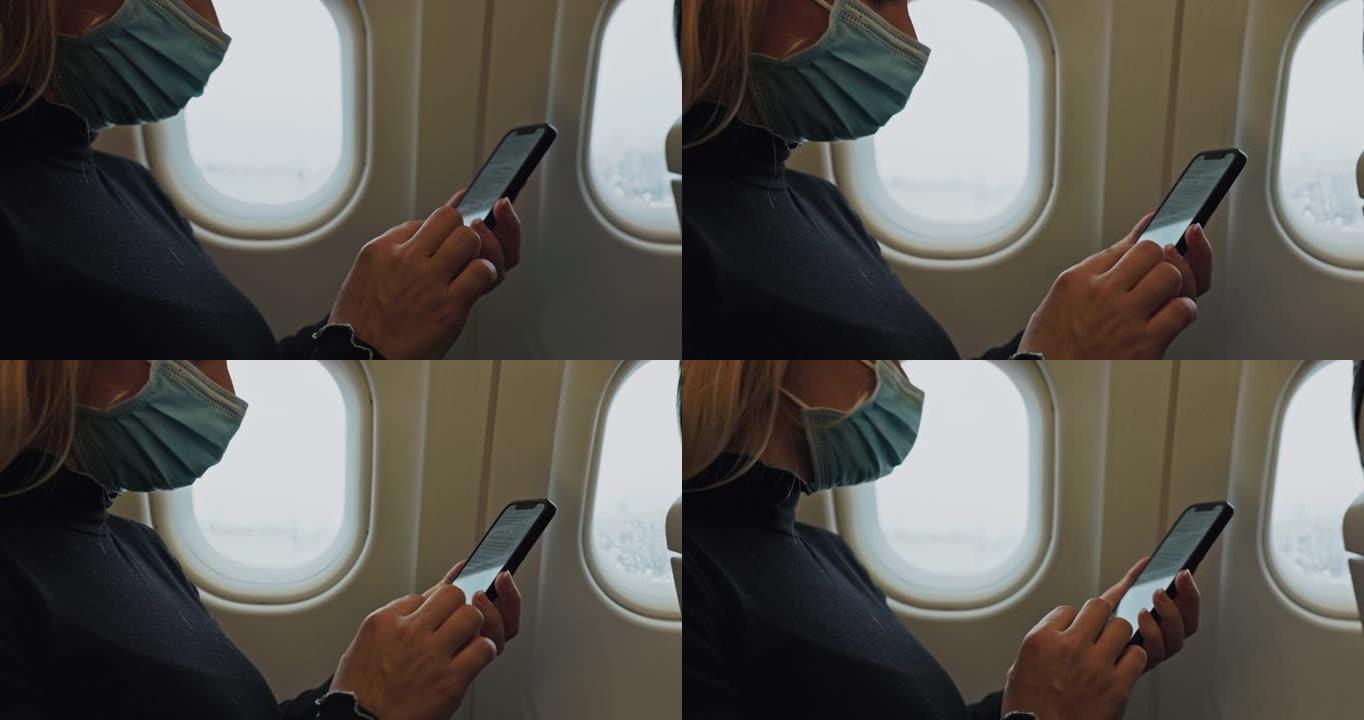 戴着医用口罩的妇女在飞机上使用手机