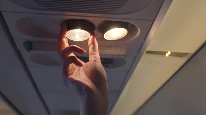 飞机顶板上的人手乘客调节阅读灯