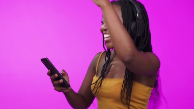 4k视频片段，一名妇女戴着耳机并使用手机跳舞