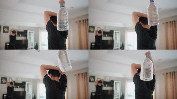 男人在家中使用塑料加仑水瓶代替健身房举重来锻炼手臂三头肌