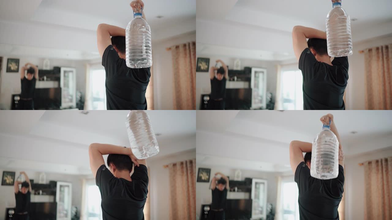 男人在家中使用塑料加仑水瓶代替健身房举重来锻炼手臂三头肌