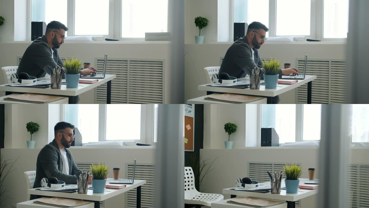 疯狂的上班族使用笔记本电脑用拳头打桌子，离开工作场所