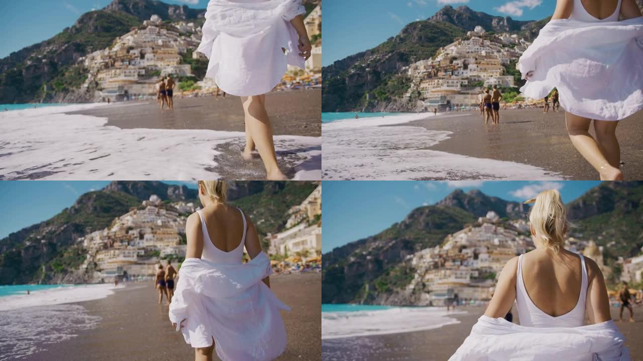 穿着白衬衫的SLO MO女人沿着著名的海滩Positano Spiaggia散步