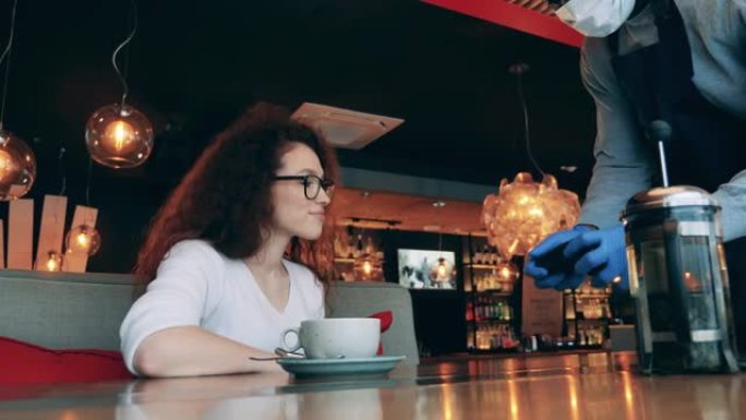 大流行期间，一名妇女正在使用智能手表在咖啡馆付款