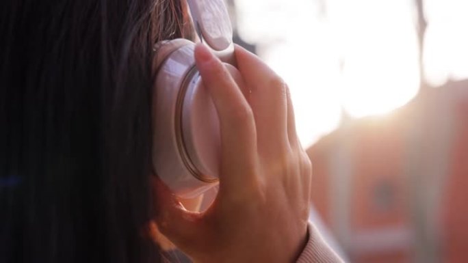 特写年轻女性戴着耳机听音乐