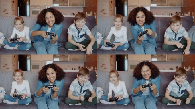 兴奋的孩子和保姆的快速运动，享受电子游戏的乐趣和在家里的笑声