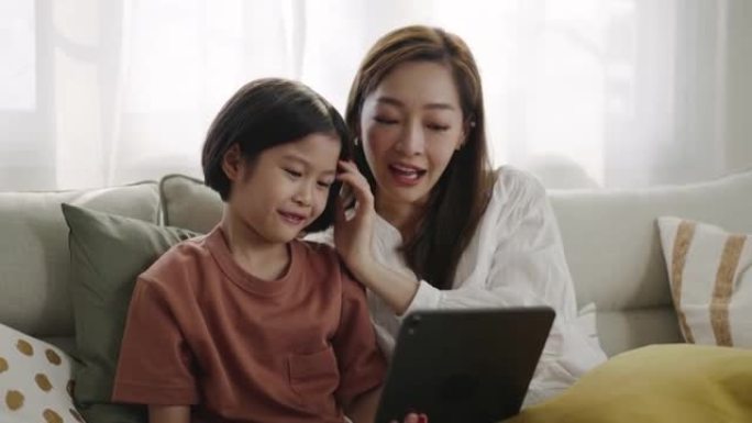 女儿和母亲在家用数字平板电脑在线学习