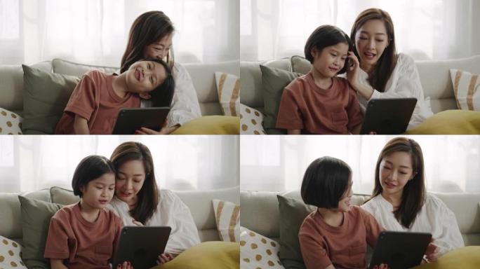 女儿和母亲在家用数字平板电脑在线学习