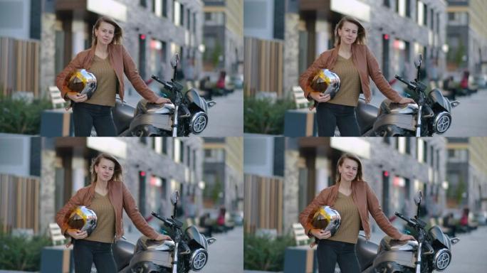 迷人的骑自行车的女人站在他的摩托车与铬头盔在城市。受孕摩托车手和摩托车。前视司机女孩站在城市生活场景