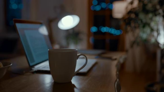 DS笔记本电脑，智能手机和一杯热饮在晚上的桌子上