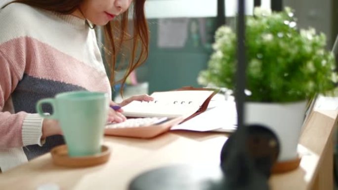 亚洲妇女在家中使用笔记本电脑工作