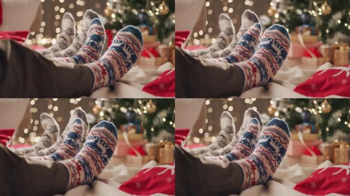 两个人坐在地板上的毯子上，穿着圣诞袜移动脚