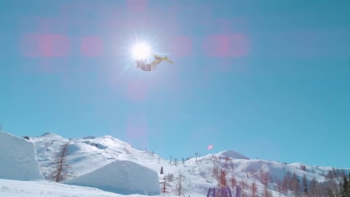 慢动作: 自由式滑雪者在跳跃大型空中踢脚时执行抓斗技巧