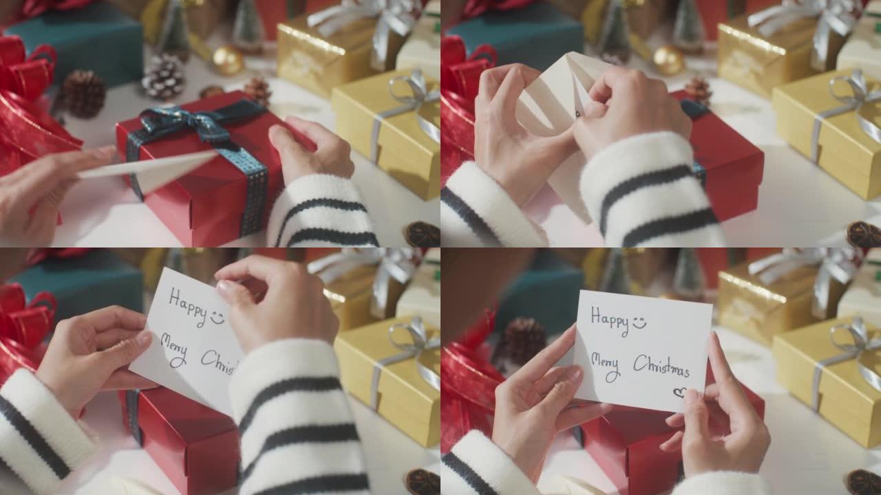 女孩手的特写打开礼物礼品盒红色背景的冬季圣诞装饰品。