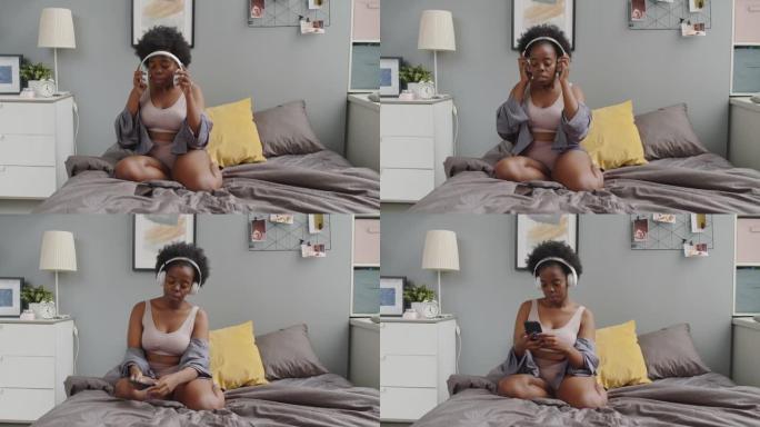 非裔美国妇女在床上戴上耳机