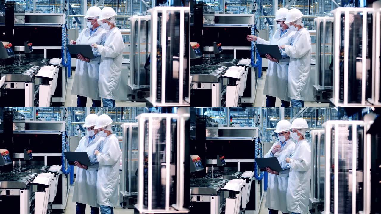 两名工厂工程师正在观察太阳能电池板的制造