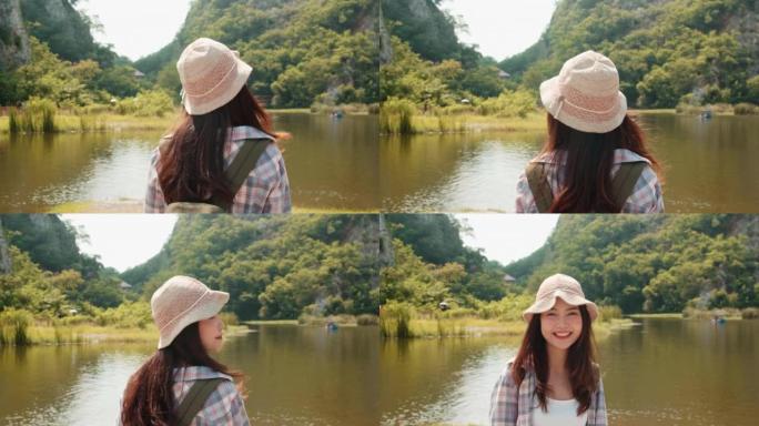 开朗的年轻旅行者亚洲女士，背着背包在山湖散步。