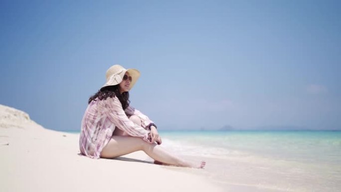 夏天坐在沙滩上放松的亚洲女人
