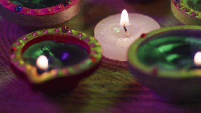 装饰陶罐中的点燃蜡烛和木制桌面上的茶灯蜡烛，bokeh背景