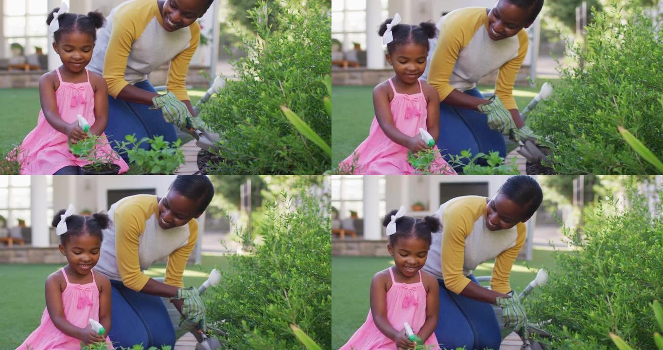 快乐的非洲裔美国母女在花园里园艺、种植和浇水