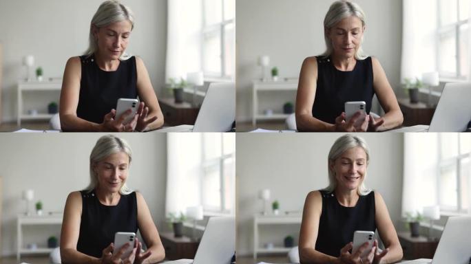 微笑的中年妇女打字信息持有现代智能手机