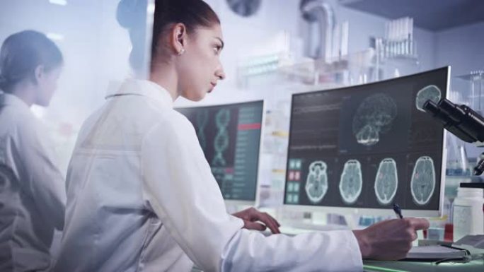 实验室的女科学家。计算机屏幕上的脑电波扫描研究