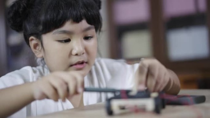 女孩学习在家中构建和固定机器人玩具干研究