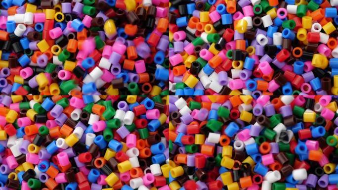 许多彩色易熔塑料珠。特写。
