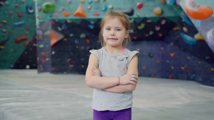 美丽的小女孩在室内攀岩设施中独自站在镜头前
