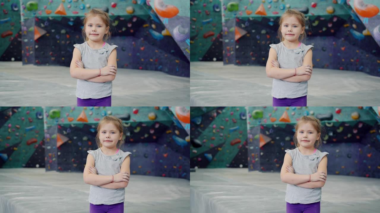 美丽的小女孩在室内攀岩设施中独自站在镜头前