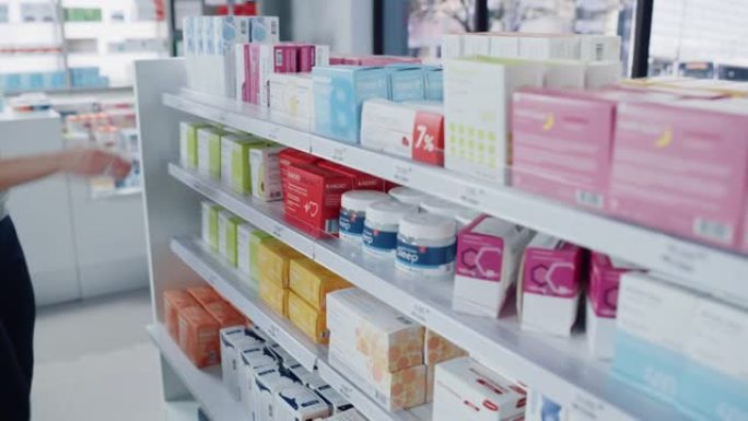 药房药店: 女人选择并挑选最好的药品包装，补充盒，药物，货架上的药丸，然后去收银台购买。现代制药商店